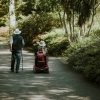 Happy senior couple enjoying the outdoors, a key benefit of buying a mobility scooter.
