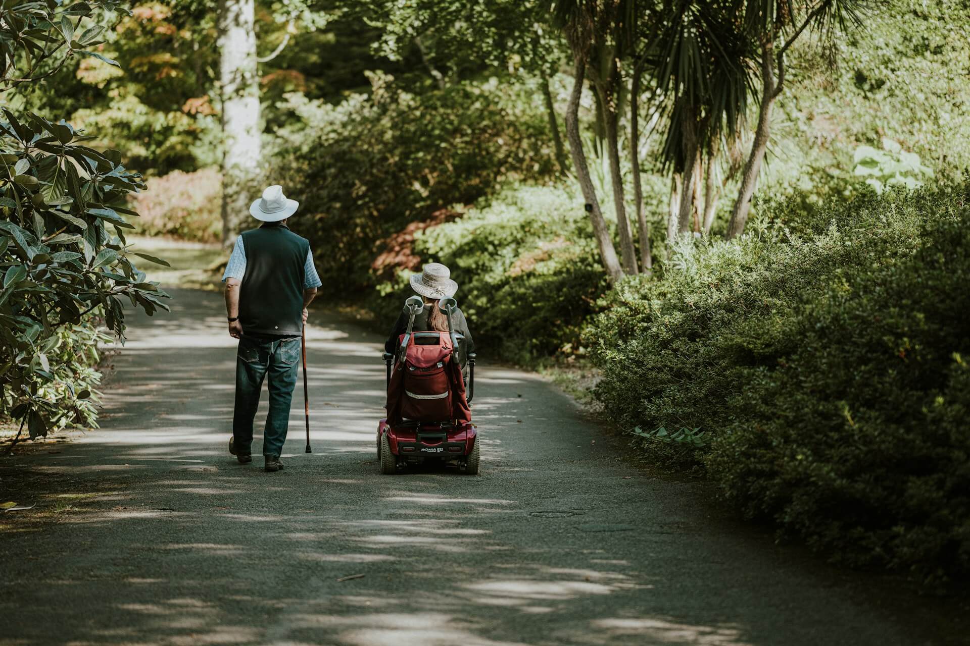Happy senior couple enjoying the outdoors, a key benefit of buying a mobility scooter.